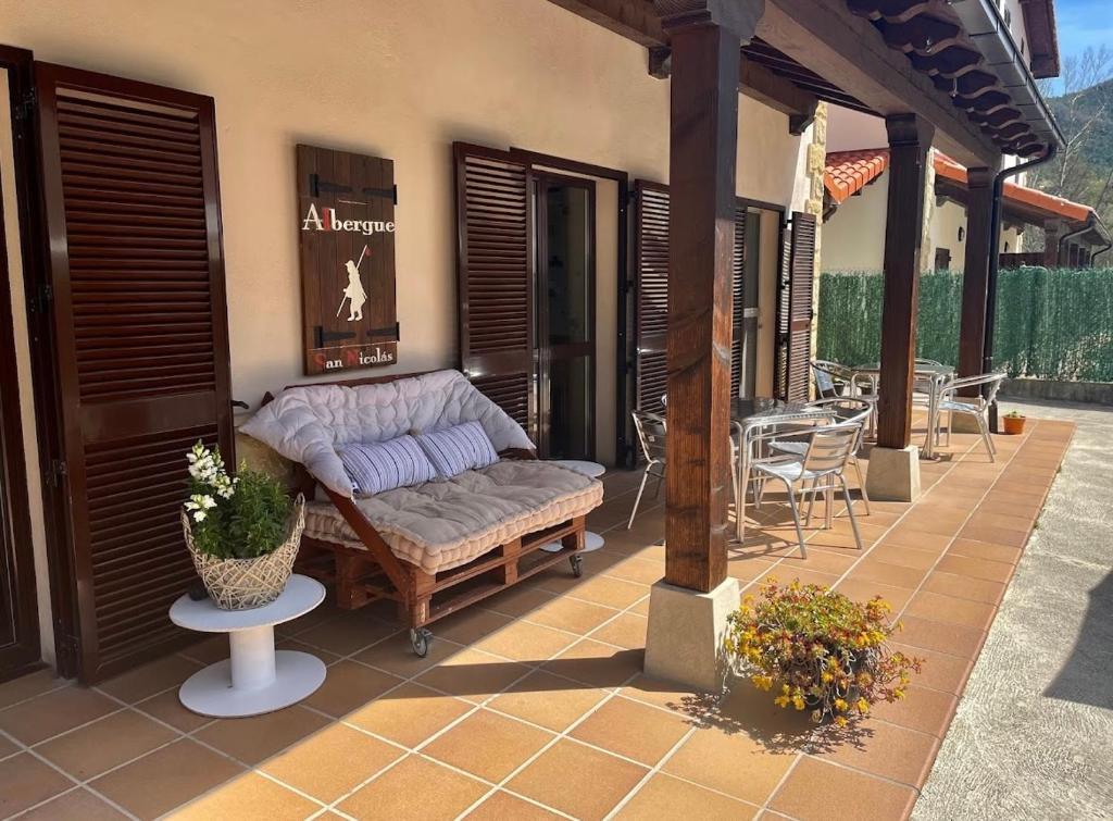 un patio con sofá, mesa y sillas en ALBERGUE SAN NICOLAS, en Larrasoaña