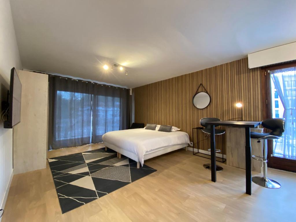 een slaapkamer met een bed, een tafel en een bureau bij Studios & chambres aux portes de Genève in Saint-Julien-en-Genevois