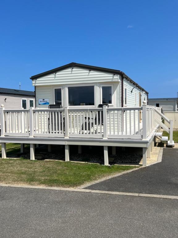 a large white mobile home with a large deck at The Vale @Barmston in Barmston