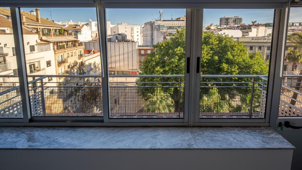 ein Fenster mit Stadtblick in der Unterkunft Hostal Antiguo Palacio Hotel París in Huelva