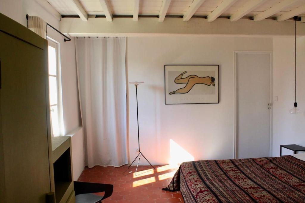 1 dormitorio con 1 cama y una foto de un caballo en la pared en Les Bleuets, en Rue
