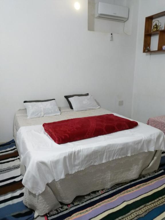 a bed with a red blanket on it in a room at DAR BRAHIM 