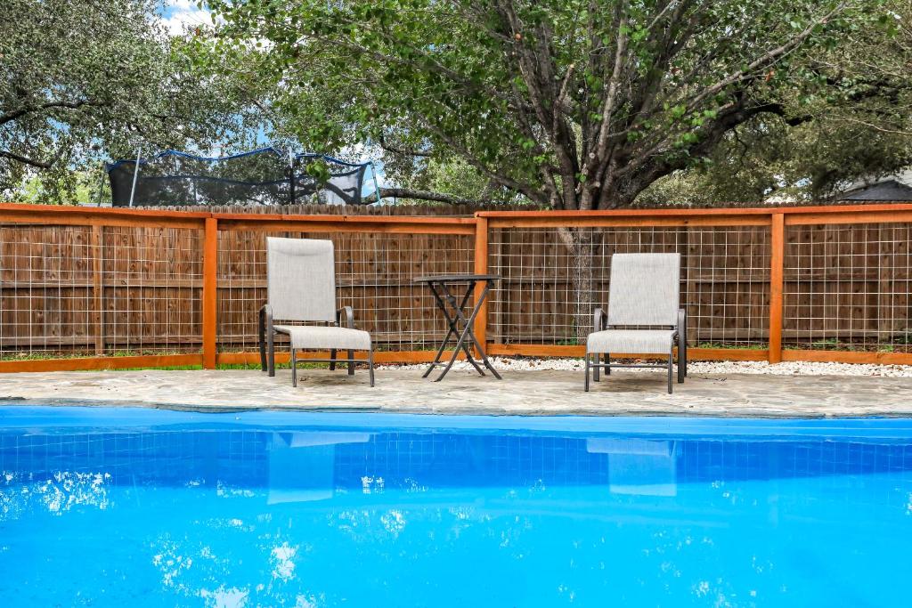 due sedie e un tavolo accanto alla piscina di King Bd Family Seaworld Hill Country Pool Fun a San Antonio