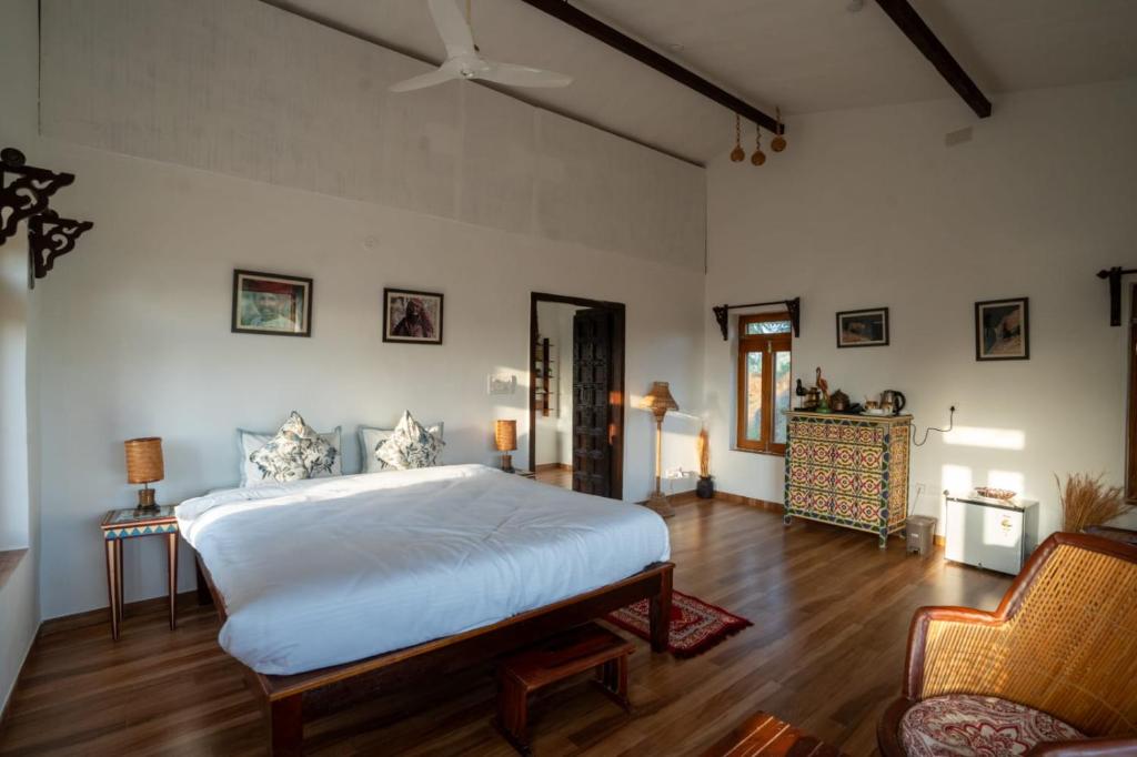 1 dormitorio con 1 cama blanca grande y 1 silla en Jawai Legacy Shambhala, en Sheoganj