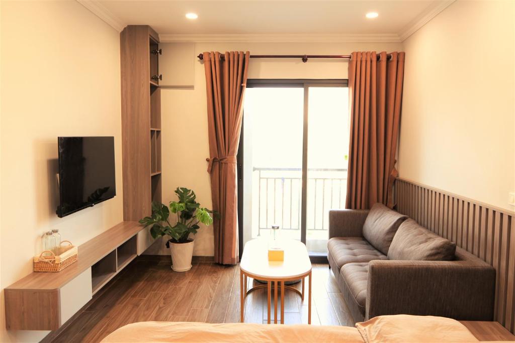 - un salon avec un canapé et une télévision dans l'établissement Funhome Apartment Giang Vo Ha Noi, à Hanoï