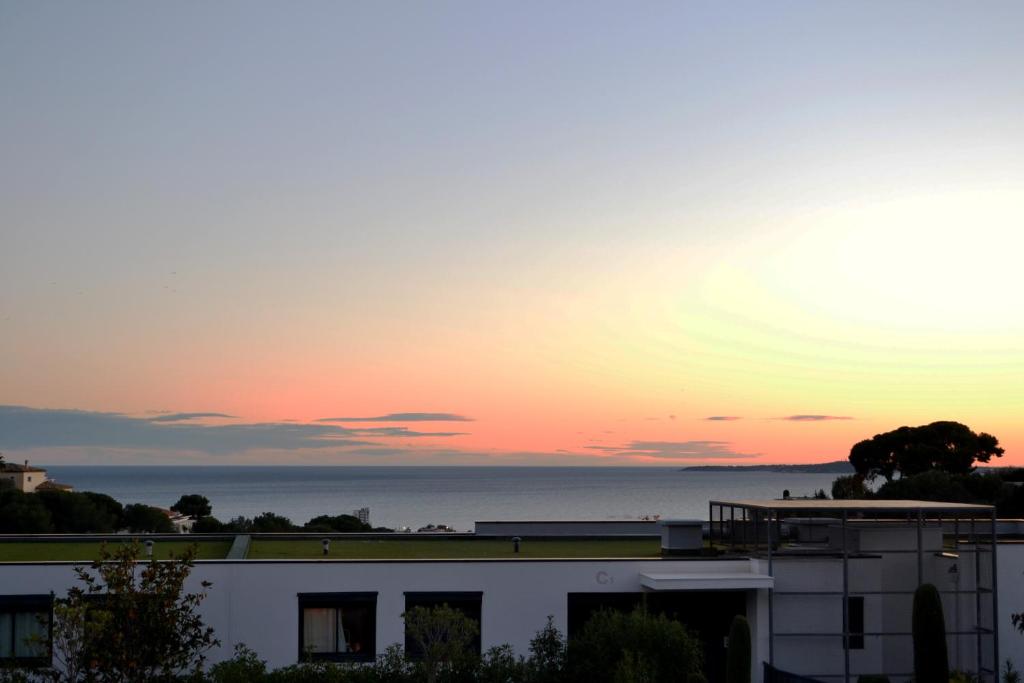 - un coucher de soleil sur l'océan depuis un bâtiment dans l'établissement Charmant 2P de 45m2 au calme, Vue Mer Panoramique, Terrasse Privée 30m2, Piscine, à Saint-Laurent-du-Var