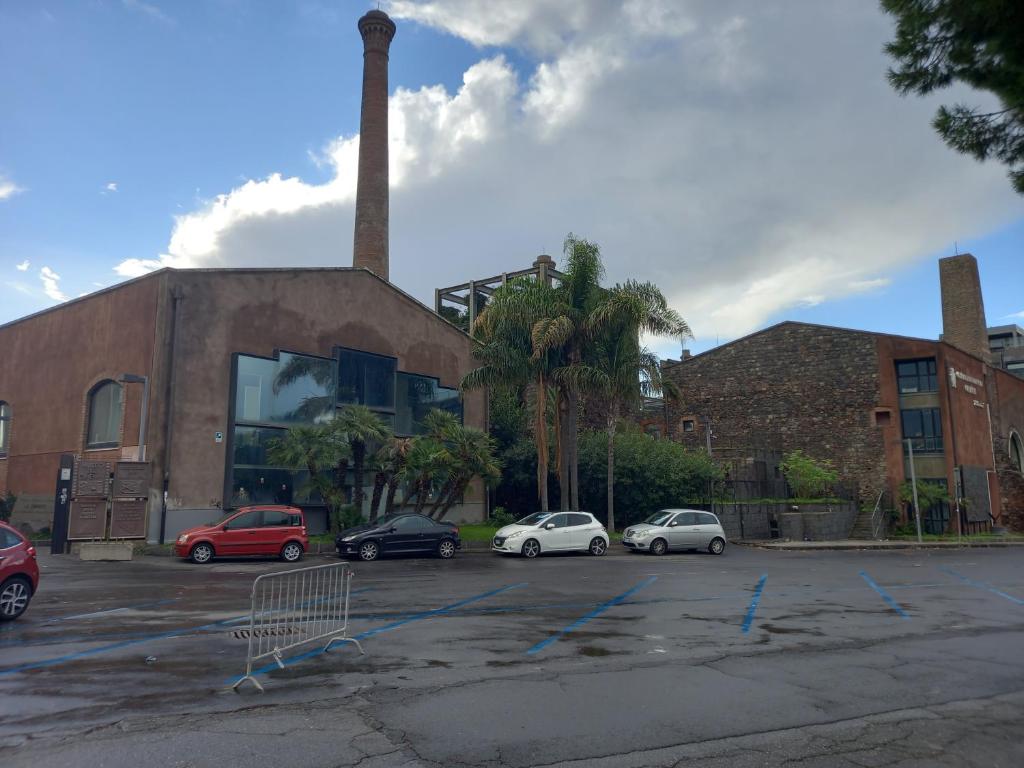 parking z samochodami zaparkowanymi przed budynkiem w obiekcie Flavi Home B&B w Katanii