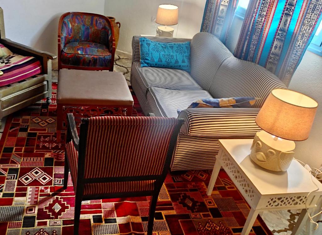 a living room with a couch and a chair at L'Oasis à Tozeur in Tozeur