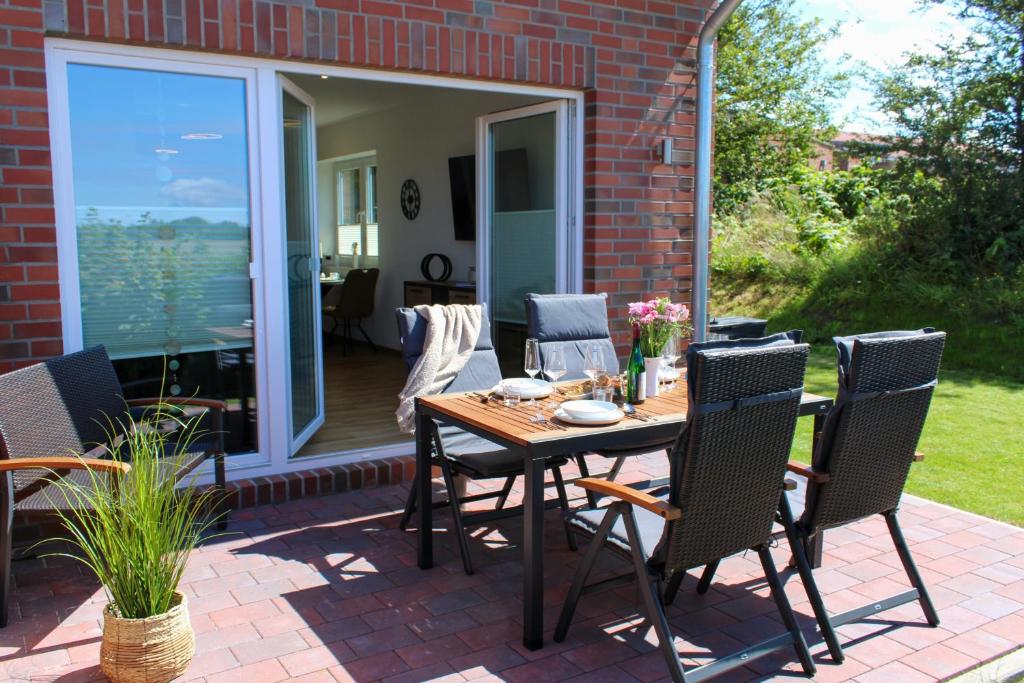 a patio with a wooden table and chairs at Nr 19 - Ferienhaus "Florentina" in Carolinensiel