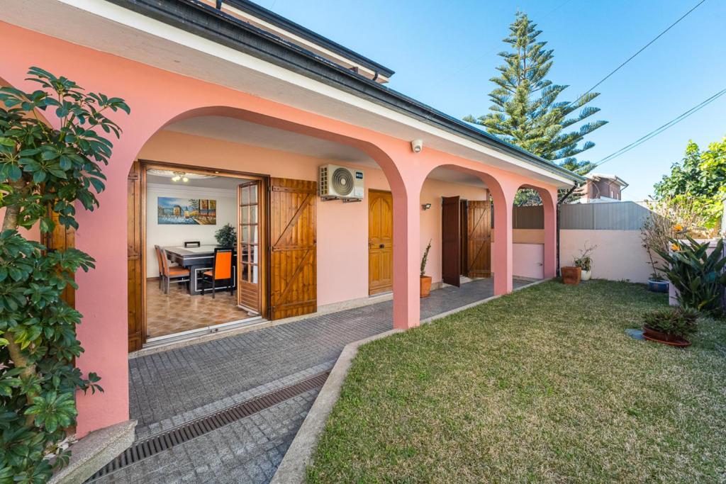 a home with a pink house with a yard at Charming and Calm House - 5 minutes from the Beach by car in Vila Nova de Gaia