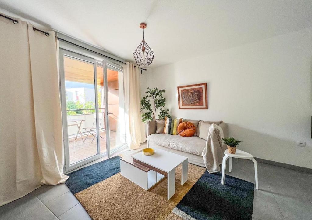 sala de estar con sofá y mesa en Confortable T2 pour 4 voyageurs, parking privé et terrasse, en Toulouse