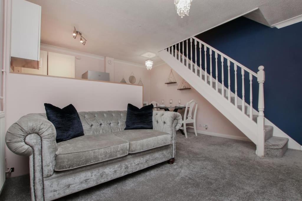 a living room with a couch and a staircase at Hurrell House in Boreham