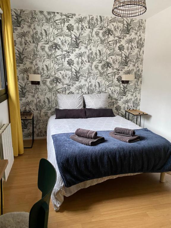 - une chambre avec un lit et un papier peint floral dans l'établissement L'appart Duplex, au Havre