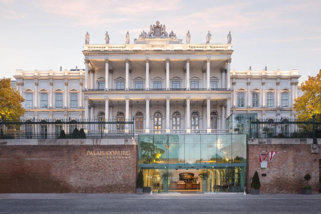 a building with a glass storefront in front of it at Palais Coburg Hotel in Vienna