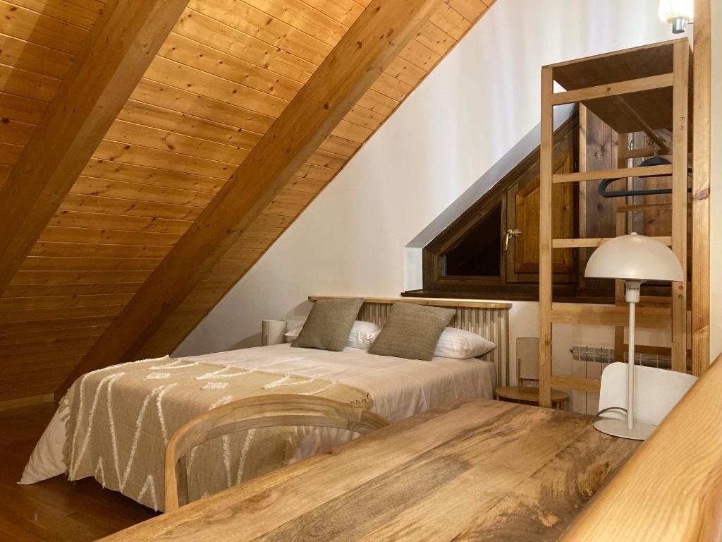 - une chambre avec un lit et un plafond en bois dans l'établissement Apartamento A10 de Formigal, 9 personas, amplio y garaje, à Escarrilla