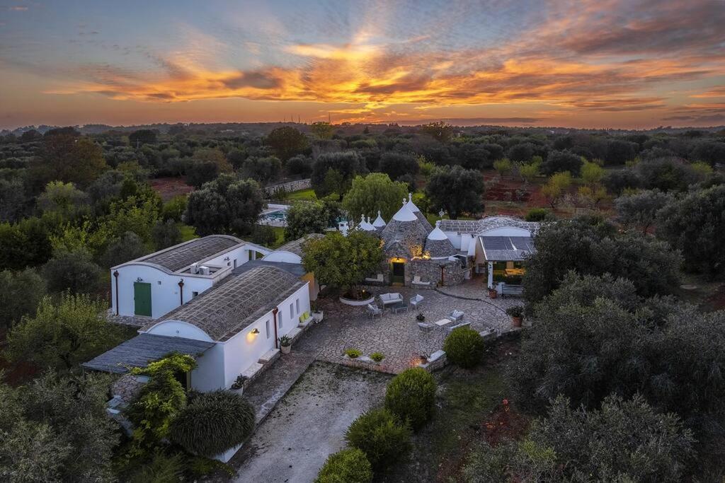 an aerial view of a house with a sunset in the background at Trulli Li Cridd in Ceglie Messapica