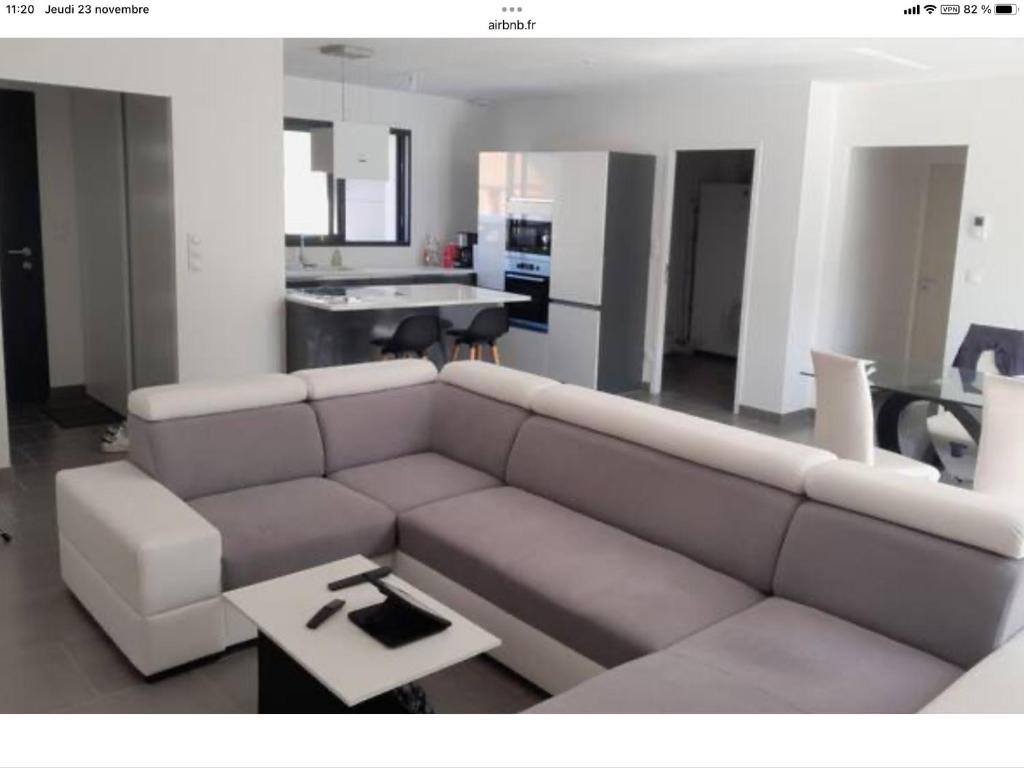sala de estar con sofá y mesa en Maison 24h du Mans et jeux olympiques, en Moncé-en-Belin