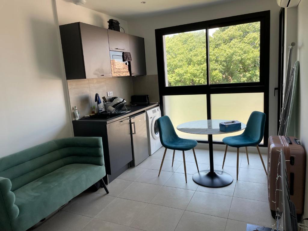 salon ze stołem i krzesłami oraz kuchnię w obiekcie studio balcon, centre ville, parc expo, Arena w mieście Pérols