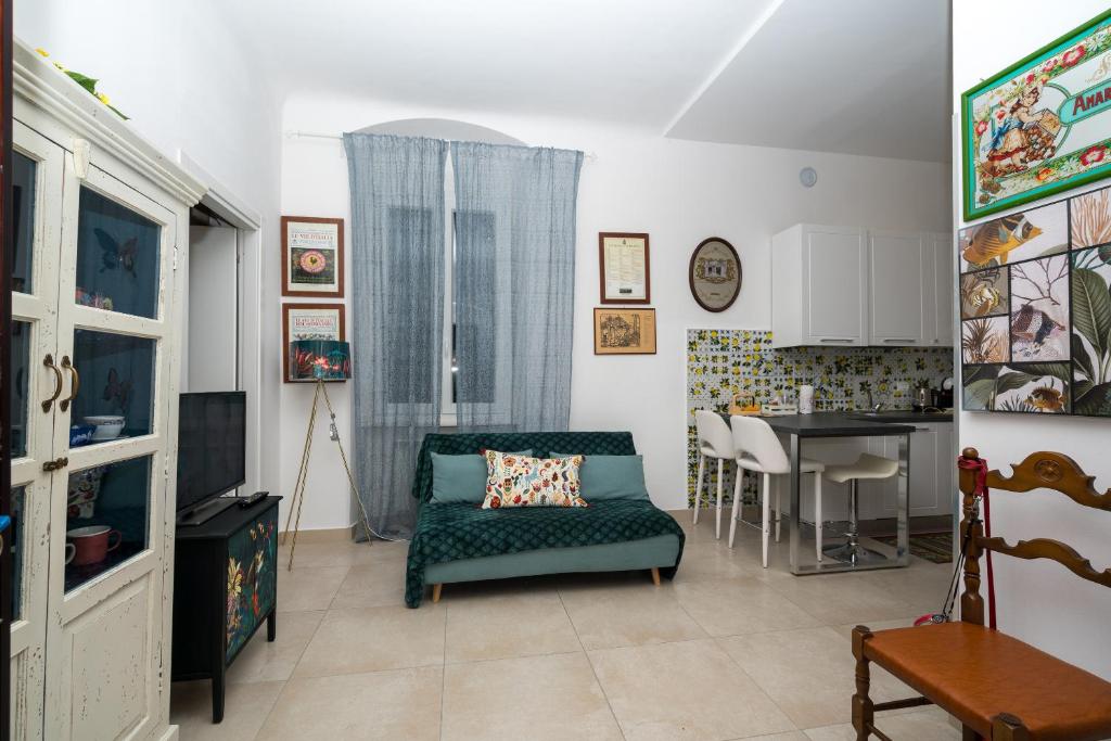 sala de estar con sofá verde y cocina en Comfort TwoBook - CITRA 011015-LT-2159, en La Spezia