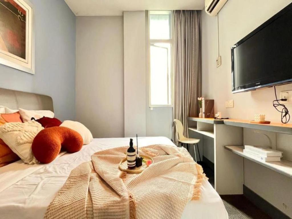 a bedroom with a bed and a flat screen tv at Swing & Pillows - KL Sg Besi formerly known as U Pac Hotel in Kuala Lumpur