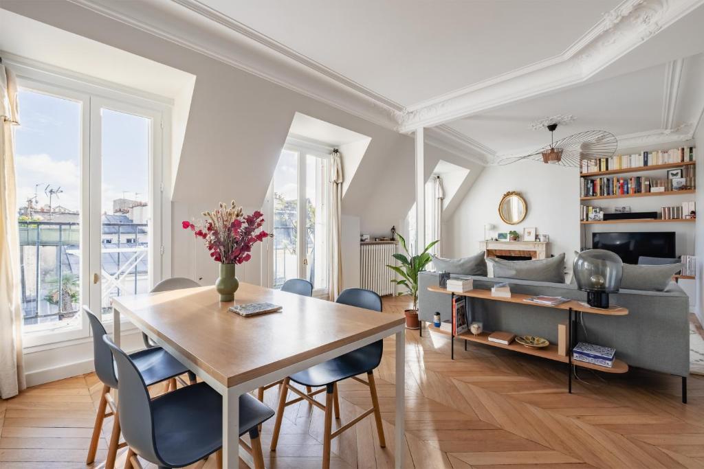 un salon avec une table, des chaises et un canapé dans l'établissement Veeve - Bright Skies, à Paris
