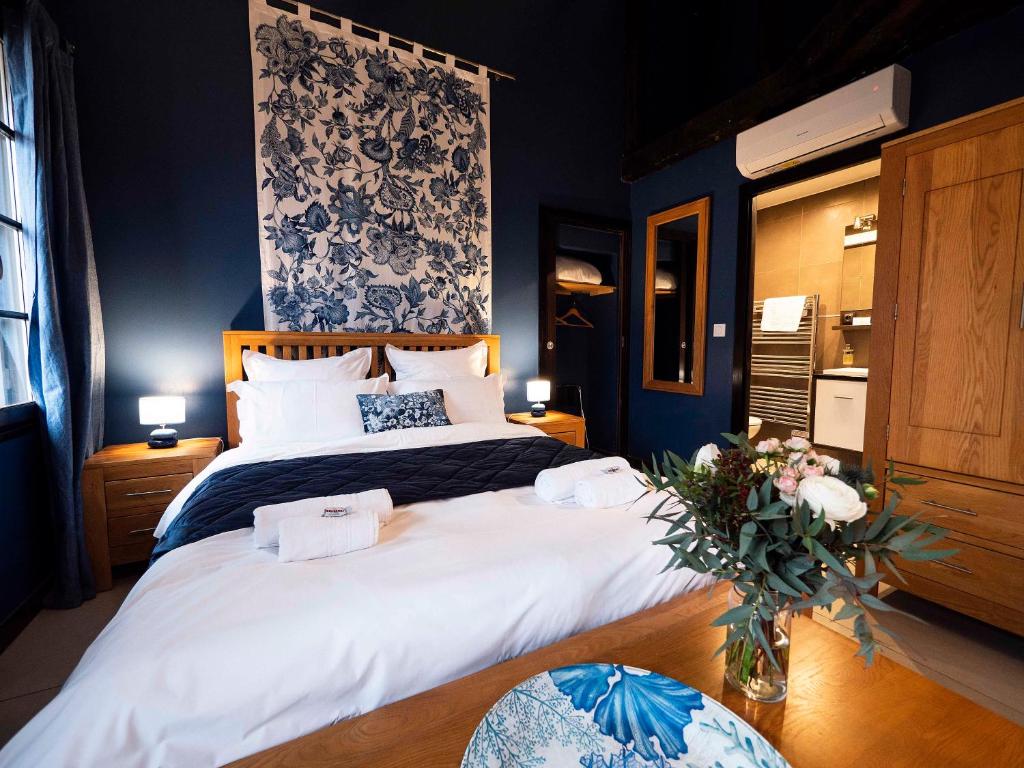 - une chambre avec 2 lits et un vase de fleurs dans l'établissement Suites Coronell d'En Vila, à Perpignan
