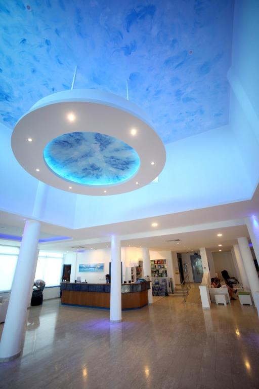 a lobby with a blue ceiling with a large aquarium at Anonymous Beach Hotel (Adults 16+) in Ayia Napa