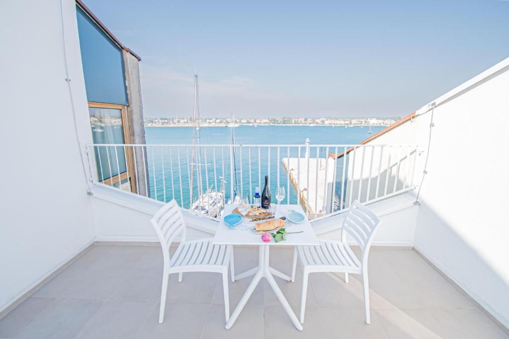 a white balcony with a table and chairs and the ocean at apartment seafront Umag center old town seaview rentistra 4 in Umag