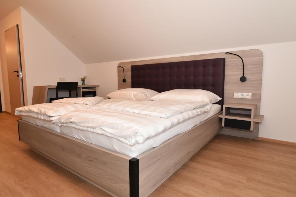 um quarto com uma cama grande e lençóis brancos em Village Loft em Sankt Stefan im Rosental