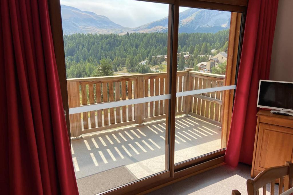 um quarto com uma grande janela com vista para a montanha em Superb well-equipped apartment em Le Dévoluy