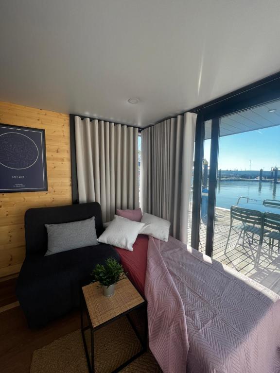 a bedroom with a bed and a couch and a table at Casas Flotantes - Boatvillage in Ayamonte
