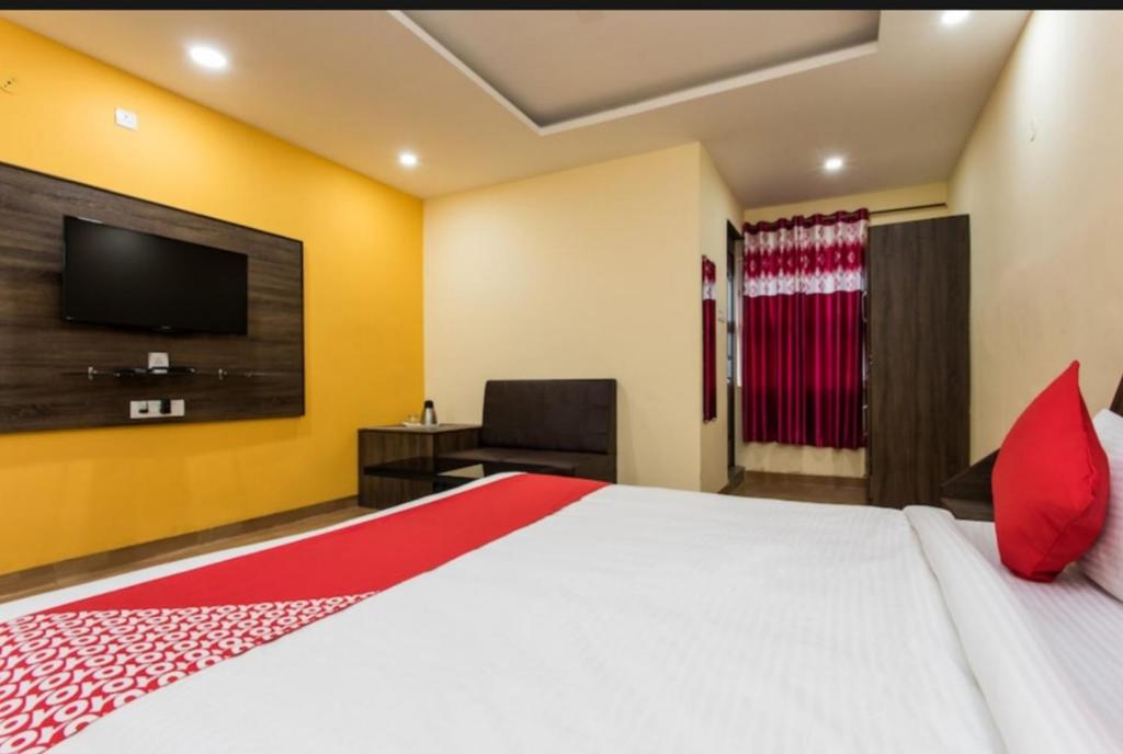 a bedroom with a large bed and a flat screen tv at Fun and Food Resort & Holidays in Harsola