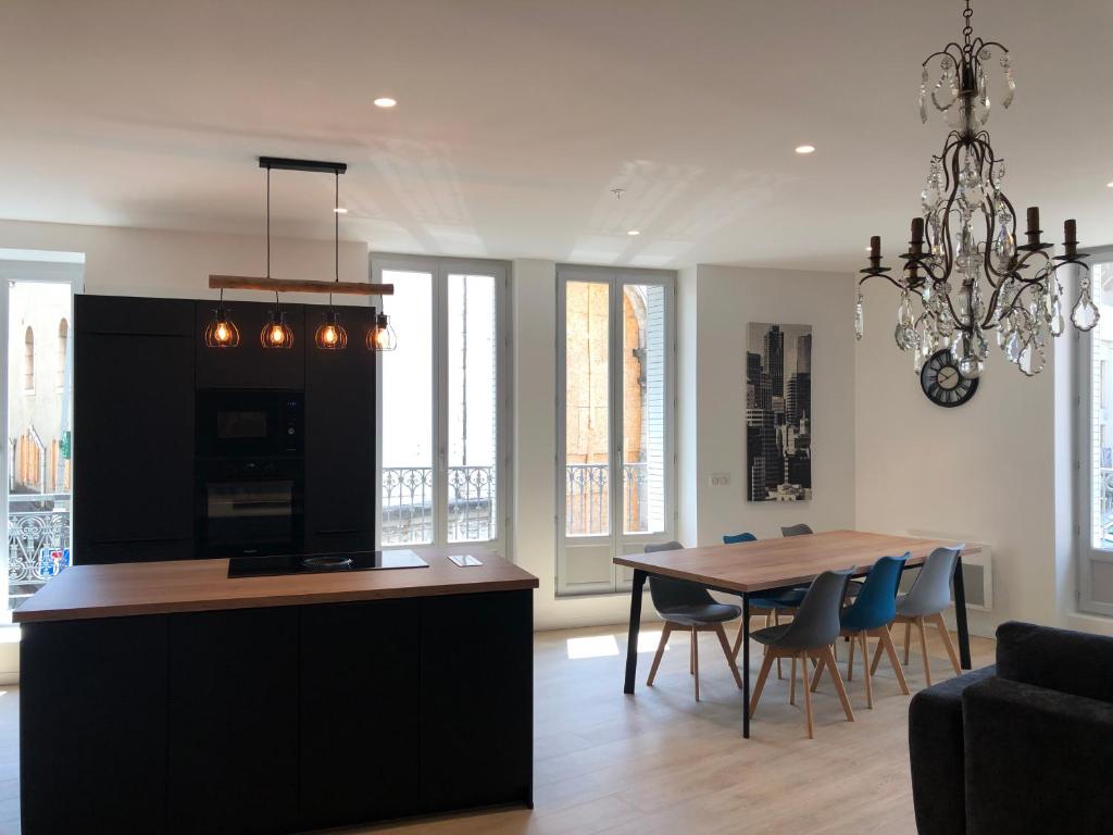 une cuisine et une salle à manger avec une table et un lustre dans l'établissement Appartement T3 Hippocrate 106 m2 centre-ville, à Aix-les-Bains