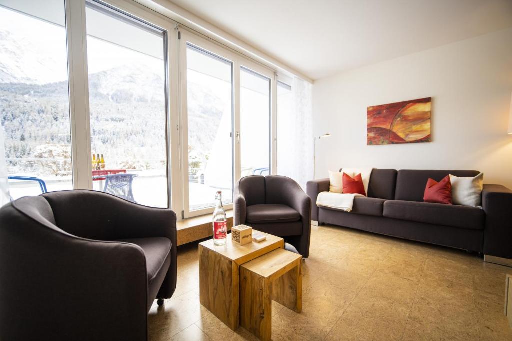 a living room with a couch and chairs and a table at Chasa Tulai F83 in Scuol
