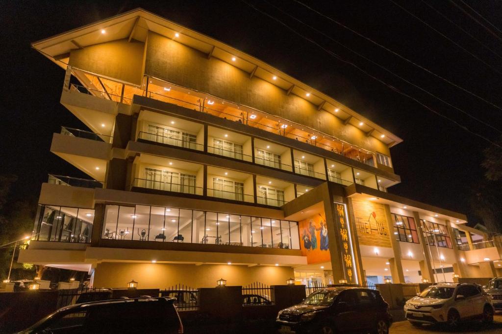 un bâtiment avec des voitures garées devant lui la nuit dans l'établissement The Hut Restaurant & Boutique Hotel, à Kigali