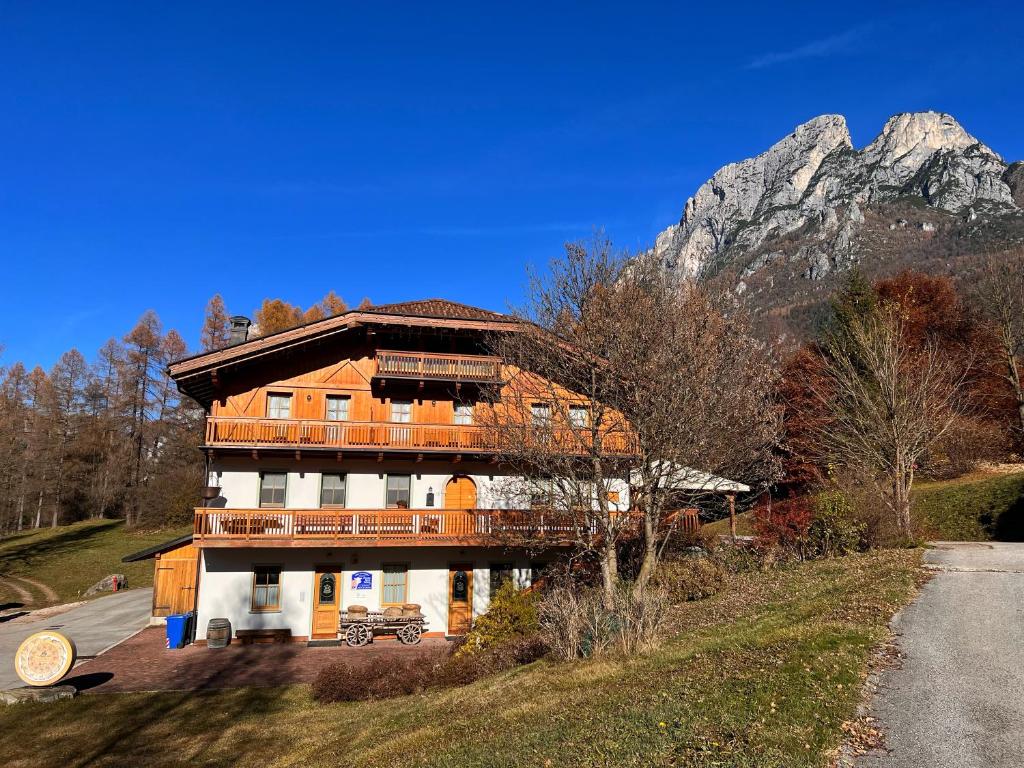 un gran edificio con una montaña en el fondo en Agriturismo Busa dei Sbrase 