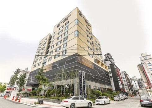 a large building with cars parked in front of it at Ulsan Samsan Pandora Hotel in Ulsan