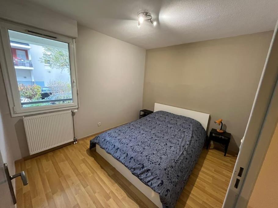 - une chambre avec un lit et une grande fenêtre dans l'établissement Charmant T2 + parking et balcon, à Strasbourg