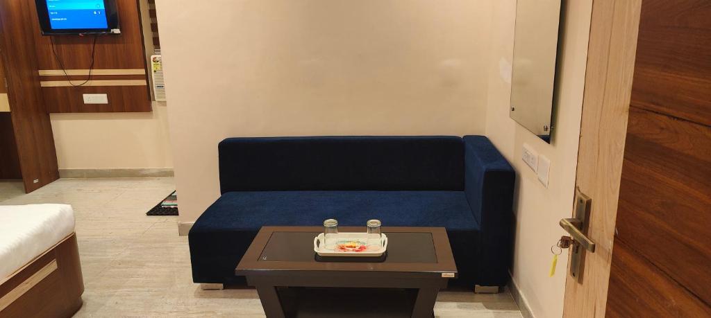 une chambre avec un canapé bleu et une table dans l'établissement Hotel Jayadeep, à Bhubaneswar