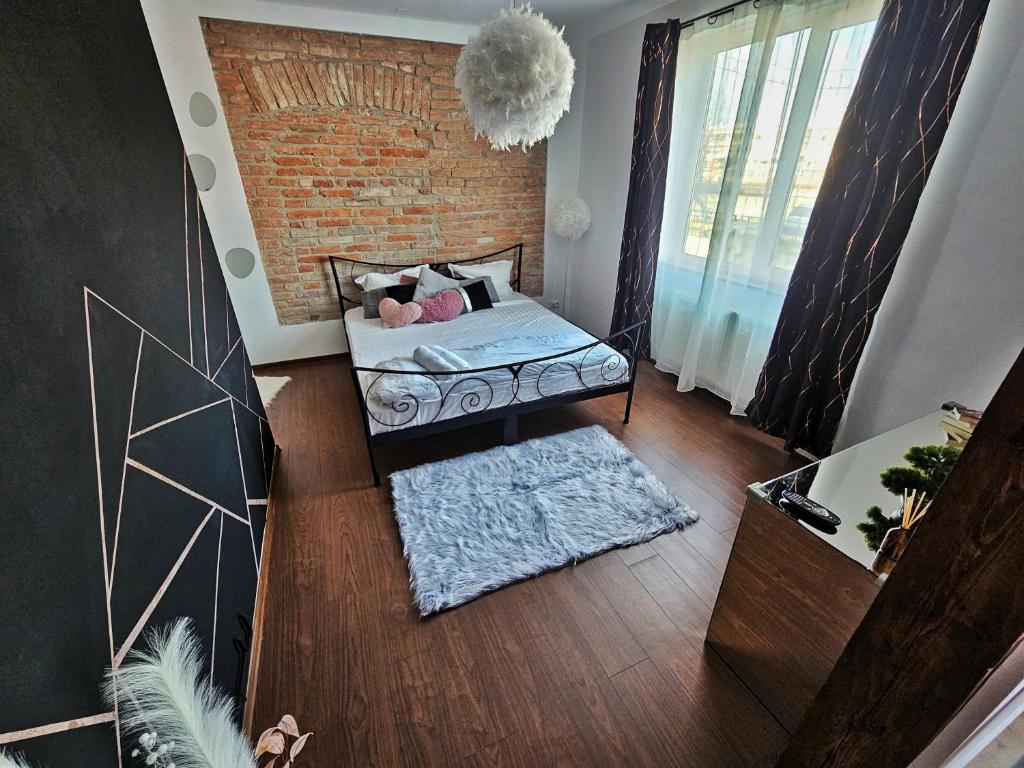 a room with a bed and a brick wall at Central Station Apartment in Cluj-Napoca