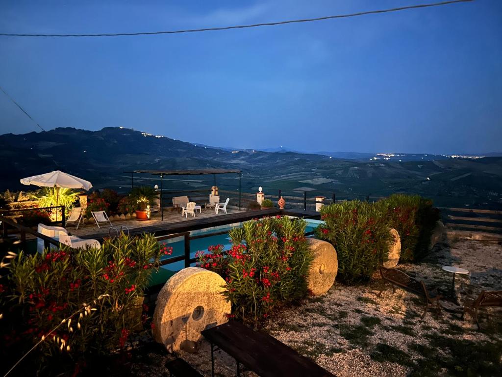 a house with a swimming pool with mountains in the background at Casale Galati in Sciacca