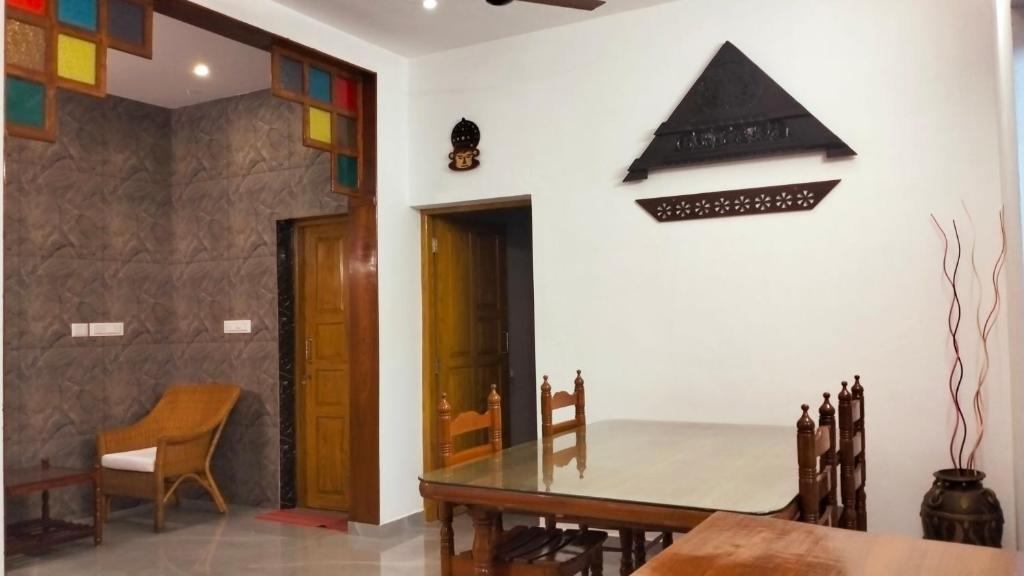 una sala da pranzo con tavolo e sedie in legno di Guestland Homestay a Cochin