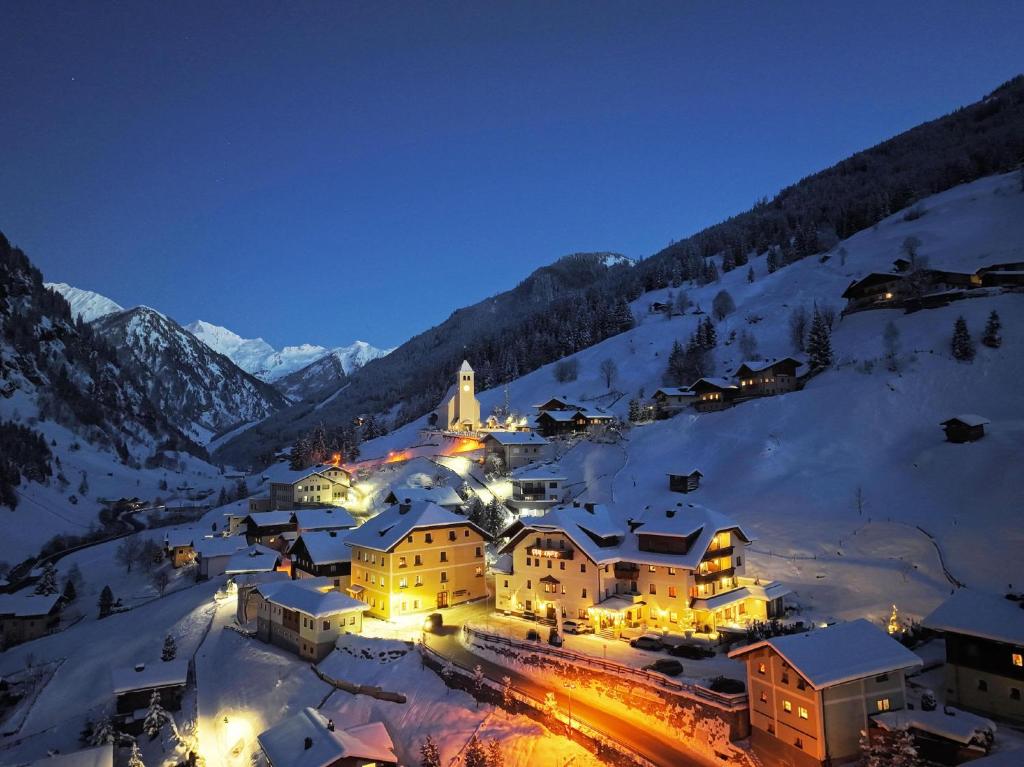 un pequeño pueblo en la nieve por la noche en Natur- & Auszeithotel Hüttenwirt, en Hüttschlag