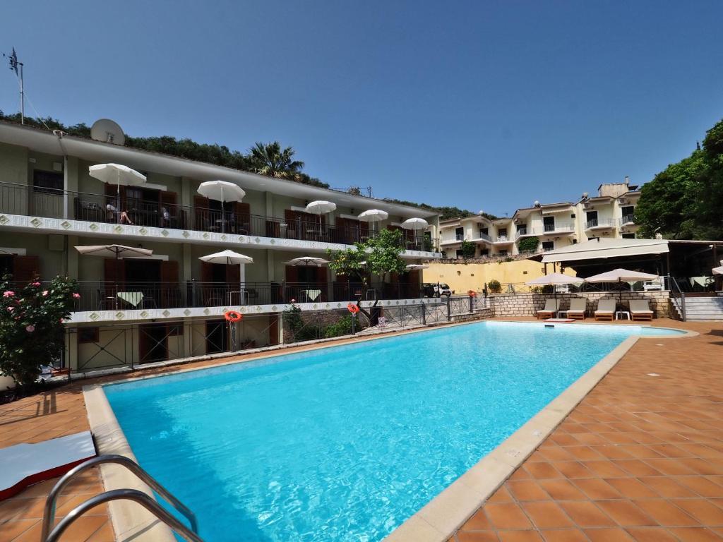 a large swimming pool in front of a hotel at Bella Vista Hotel Studios & Apartments in Parga