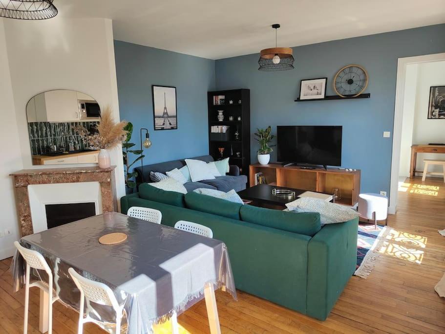 - un salon avec un canapé vert et une table dans l'établissement Appartement calme et lumineux à Clichy, à Clichy