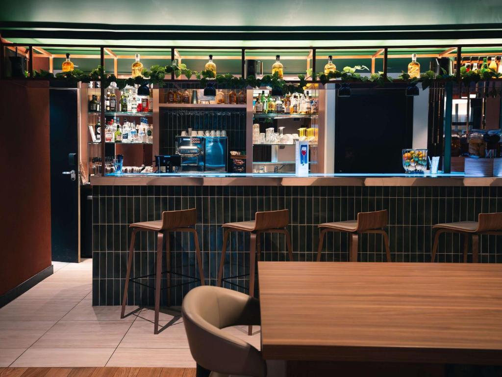 a restaurant with a bar with stools at Novotel Lille Centre Grand Place in Lille