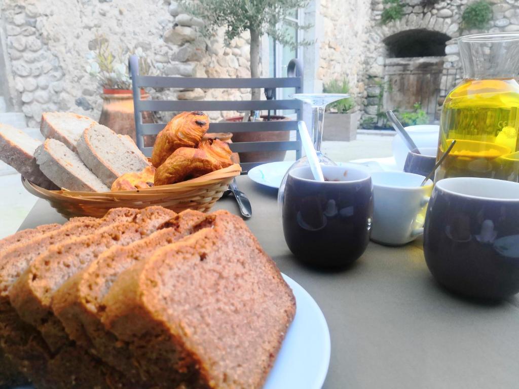 a table with a plate of bread and a basket of chickens at La Secrète in Vogüé