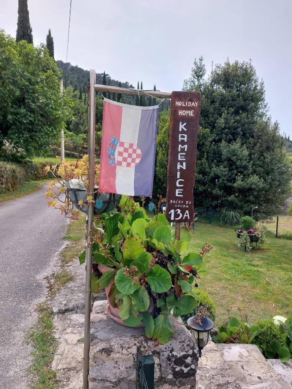 a flag and a sign on the side of a road at Holiday Home Kamenice in Gruda