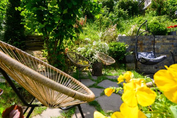 a garden with three chairs and some flowers at Pensiunea GreenHill in Braşov