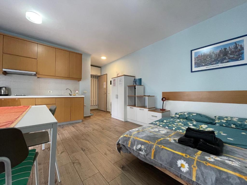 mały pokój z łóżkiem i kuchnią w obiekcie Enjoy Travel Cute Studio Apartment w Tiranie